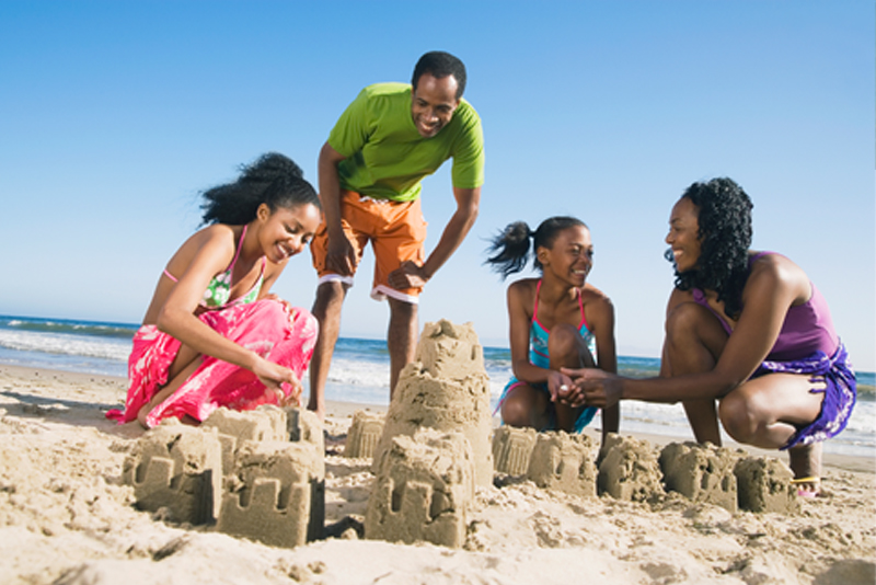 Happy family building sandcastles at the beach
